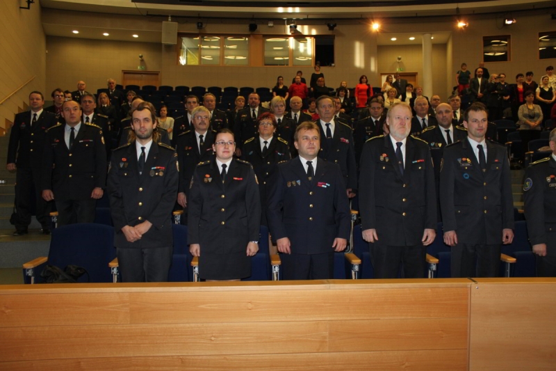 Hasiči v uniformách při slavnostním ceremoniálu v aule
