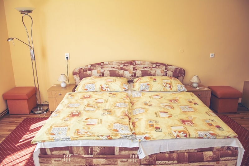 Manželská postel s nočními stolky a lampičkami