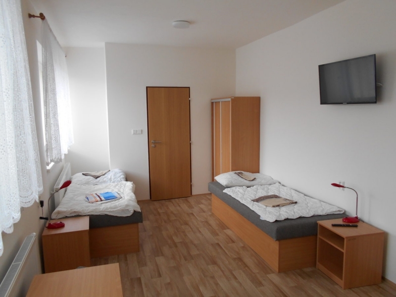 Dvoulůžkový pokoj s televizí na stěně